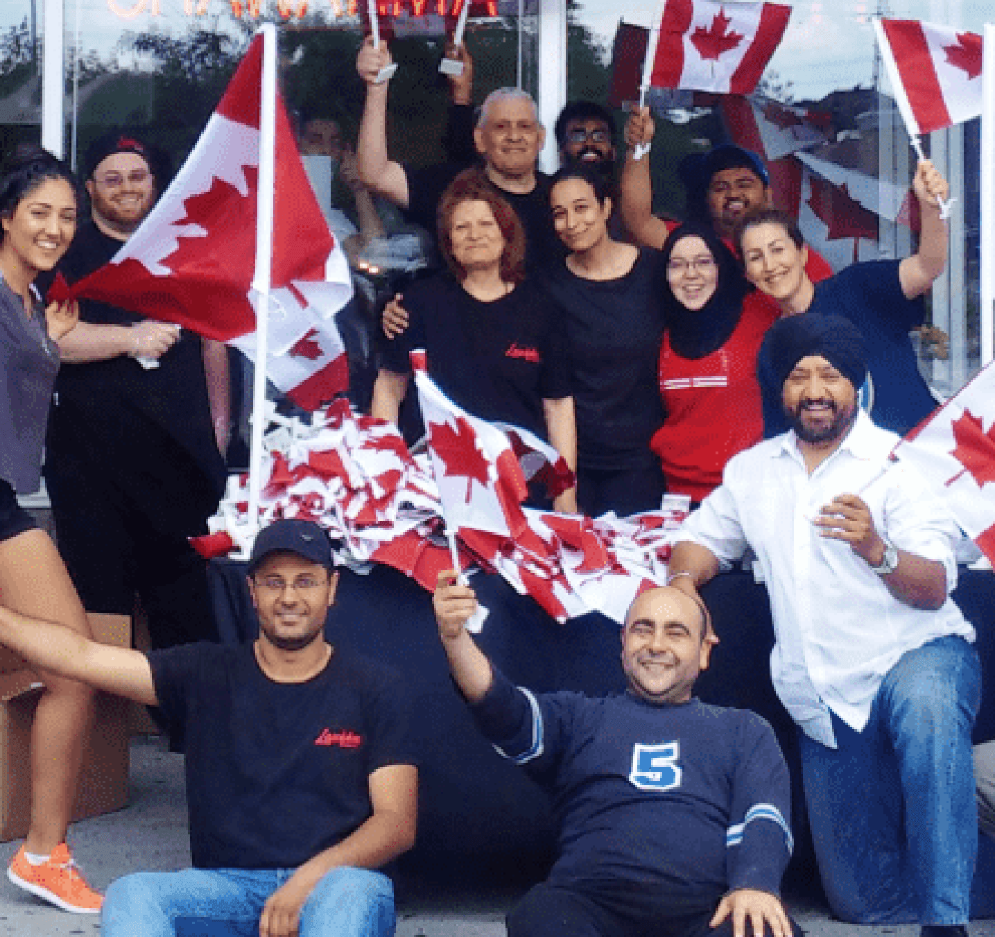 Celebrating a grand opening with Canadian flags outside a lazeez location